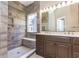 Well-lit bathroom featuring a double sink vanity and a beautifully tiled walk-in shower with a window at 9569 Indigo Club Dr., Murrells Inlet, SC 29576