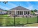 Backyard with patio, outdoor seating, and a well-maintained lawn, all enclosed by a sleek black fence at 967 Henry James Dr., Myrtle Beach, SC 29579