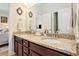 Bathroom showcasing dual vanities, granite counters, and dark wood cabinets, offering both elegance and functionality at 967 Henry James Dr., Myrtle Beach, SC 29579