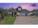 Charming brick home featuring a three-car garage, landscaped yard, and palm tree, with a colorful sunset sky at 967 Henry James Dr., Myrtle Beach, SC 29579