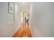 Inviting hallway with hardwood floors, white walls adorned with pictures, and an open view to the rest of the home at 967 Henry James Dr., Myrtle Beach, SC 29579