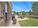 Outdoor dining area and grill on the concrete patio, surrounded by a well-maintained lawn and a black metal fence at 967 Henry James Dr., Myrtle Beach, SC 29579