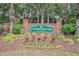 Neighborhood entrance sign, 'Covington Lake East,' surrounded by manicured landscaping and flowering plants at 967 Henry James Dr., Myrtle Beach, SC 29579
