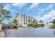 Beautiful building with landscaping, driveway, and sky background, with palm trees and garden areas at 101 Ocean Creek Dr. # Dd7, Myrtle Beach, SC 29572