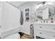 Charming bathroom with a round mirror, white vanity, and stylish decor, creating a relaxing and inviting atmosphere at 1014 Thomas Ave., North Myrtle Beach, SC 29582