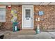 Charming entryway with brick facade, adorned with a variety of decorative items and a glass panel door at 1014 Thomas Ave., North Myrtle Beach, SC 29582