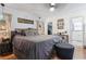 Comfortable bedroom with gray bedding, an ottoman, and a glimpse into a walk-in closet at 113 Woodland Dr., Murrells Inlet, SC 29576