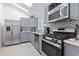 Modern kitchen with stainless steel appliances, gray cabinets, and sleek countertops, offering style and functionality at 113 Woodland Dr., Murrells Inlet, SC 29576