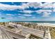 Beachside boardwalk with tables and chairs, offering scenic ocean views and ample seating at 125 South Dunes Dr., Pawleys Island, SC 29585