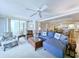 Cozy living room featuring a blue sectional sofa, ceiling fan, and access to a balcony at 125 South Dunes Dr., Pawleys Island, SC 29585