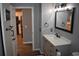 Bathroom with a modern vanity, stylish mirror, and a glimpse into the open kitchen at 1266 River Oaks Dr. # 12-F, Myrtle Beach, SC 29579