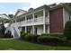 Two-story building with white railings, well-manicured landscaping, and brick accents at 1266 River Oaks Dr. # 12-F, Myrtle Beach, SC 29579