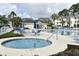 Community pool area with lounge chairs, tables, and a hot tub surrounded by well-maintained landscaping at 1266 River Oaks Dr. # 12-F, Myrtle Beach, SC 29579