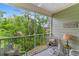 Screened-in balcony with comfortable seating and a view of lush green trees at 144 Puffin Dr. # 3C, Pawleys Island, SC 29585