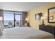 Bright main bedroom with a large bed, TV, dresser, and sliding glass doors leading to a balcony with ocean views at 1501 S Ocean Blvd. # 1231, Myrtle Beach, SC 29577