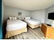 Well-lit bedroom featuring two twin beds, modern decor, and wood-look floors at 1905 S Ocean Blvd. # 922-924, Myrtle Beach, SC 29577