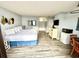 Sunlit bedroom featuring a queen bed, dresser, minifridge, and wood-look floors at 1905 S Ocean Blvd. # 922-924, Myrtle Beach, SC 29577