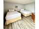 Bright bedroom featuring two twin beds, dresser, and wood-look floors at 1905 S Ocean Blvd. # 922-924, Myrtle Beach, SC 29577