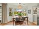 Bright breakfast nook features a rustic wooden table, modern light fixture, and bay window with views of greenery at 2170 Deerfield Ave., Surfside Beach, SC 29575