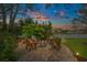 Backyard fire pit seating area with Adirondack chairs and string lights at sunset, plus lake view at 2170 Deerfield Ave., Surfside Beach, SC 29575