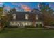 Evening view of a two story home with dormer windows and inviting curb appeal under a colorful sky at 2170 Deerfield Ave., Surfside Beach, SC 29575