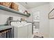 Organized laundry room with built-in shelves, side-by-side washer and dryer, and easy access to half bathroom at 2170 Deerfield Ave., Surfside Beach, SC 29575