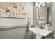 Charming powder room featuring a pedestal sink, decorative mirror, artwork, and elegant fixtures at 2170 Deerfield Ave., Surfside Beach, SC 29575