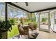 Inviting screened-in porch with woven furniture, tiled floor, and relaxing views of the lush landscaped yard at 2170 Deerfield Ave., Surfside Beach, SC 29575