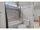 Well-lit shower over tub with grey tiling, a rain shower head and a window at 2204 Woodstork Dr., Conway, SC 29526