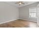 This bedroom features hardwood floors, a ceiling fan, and a window for natural light at 2204 Woodstork Dr., Conway, SC 29526