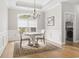 Charming dining area featuring wainscoting, hardwood floors, chandelier, and a large window at 2204 Woodstork Dr., Conway, SC 29526