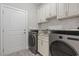 The laundry room has modern stainless steel washer and dryer with white cabinets at 2204 Woodstork Dr., Conway, SC 29526