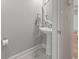 Elegant powder room features a pedestal sink with decorative mirror and gray tile flooring at 2204 Woodstork Dr., Conway, SC 29526