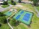 Aerial view of well-maintained tennis and basketball courts with playground and surrounding green spaces at 2204 Woodstork Dr., Conway, SC 29526