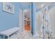 Open blue bathroom featuring a shower stall with a wicker bench and a view into the kitchen at 223 Maisons Dr. # C8, Myrtle Beach, SC 29572