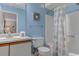 Bright bathroom with a shower/tub combo and coastal-themed shower curtain; features light blue walls and vanity at 223 Maisons Dr. # C8, Myrtle Beach, SC 29572