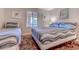 Comfortable bedroom features two twin beds with ocean-inspired bedding, a window, and a coastal-themed rug at 223 Maisons Dr. # C8, Myrtle Beach, SC 29572