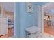 Hallway connecting to a bedroom and kitchen with a white wicker bench and blue wall at 223 Maisons Dr. # C8, Myrtle Beach, SC 29572