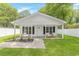 Charming home featuring a covered porch, inviting chairs, and lush green lawn at 23 Gabe Pl., Pawleys Island, SC 29585