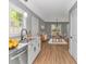 Well-lit kitchen with stainless steel appliances, white cabinets, and wood flooring at 23 Gabe Pl., Pawleys Island, SC 29585