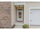 Welcoming front entrance with a brick accent wall, modern door and lush greenery at 252 Legends Village Loop, Myrtle Beach, SC 29579