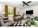 Inviting living room featuring a fireplace, large windows, a ceiling fan, and modern décor at 252 Legends Village Loop, Myrtle Beach, SC 29579