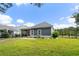 A spacious backyard with lush green grass, a screened porch, and a black iron fence at 2909 Moss Bridge Ln., Myrtle Beach, SC 29579