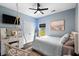 Stylish bedroom with blue walls, a pendant chair, modern ceiling fan, and a calming beach-themed artwork at 2909 Moss Bridge Ln., Myrtle Beach, SC 29579
