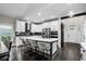 Bright kitchen featuring white cabinets, stainless steel appliances, large island with seating, and stylish design at 2909 Moss Bridge Ln., Myrtle Beach, SC 29579