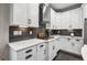 Modern kitchen with white cabinets, gas range, stainless steel range hood, and black hardware at 2909 Moss Bridge Ln., Myrtle Beach, SC 29579