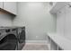 Organized laundry area with modern washer/dryer, white cabinets, and convenient built-in bench and shelving at 2909 Moss Bridge Ln., Myrtle Beach, SC 29579