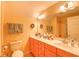 Neutral colored bathroom with double sink vanity and a full mirror, as well as the toilet at 305 Goddard Ln., Murrells Inlet, SC 29576
