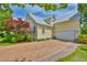 Attractive home showcasing brick driveway, lush landscaping, and a metal roof at 305 Goddard Ln., Murrells Inlet, SC 29576