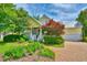 Charming yellow two-story home with a brick walkway, lush garden, and a welcoming front porch at 305 Goddard Ln., Murrells Inlet, SC 29576